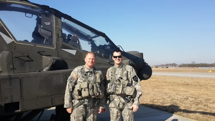 Rob, on the left, with a fellow soldier beside an Army helicopter.